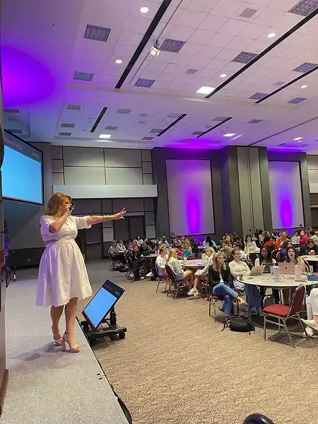 Karli presenting a keynote presentation at a women's leadership conference
