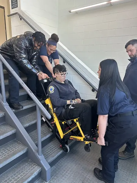 Teaching EMT students techniques for using a stairchair, a piece of equipment frequently used to help move people who are unable to ambulate.