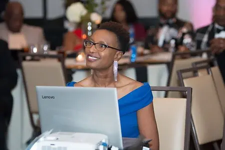 Lumbie Mlambo at her own charity gala raising funds for water projects in Africa. Here she watches and participates in the live auction with the attendees, all hoping to reach the intended goal within two hours. 