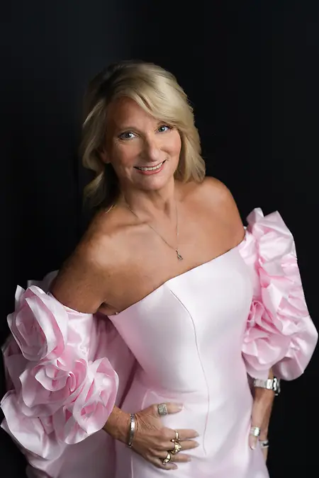 She chose the pink dress knowing some would underestimate her.

For years, she had learned how power often arrives disguised—how it’s dismissed when it doesn’t look sharp-edged or loud. She understood that leadership doesn’t always wear armor. Sometimes it wears grace, confidence, and the courage to be fully seen.

The room she walked into that night had been built through decades of perseverance. There were seasons when she led from behind the scenes, carrying teams through uncertainty, rebuilding after failures that weren’t entirely hers, and standing firm when others retreated. Strength, she learned, wasn’t about hardness—it was about resilience. The kind that bends without breaking.

The soft fabric and sculpted sleeves tell a deeper story. Every fold represents a moment she chose herself: speaking when silence was expected, leading with empathy when control would have been easier, and refusing to shrink to fit someone else’s expectations. She had faced doubt—external and internal—and met it with preparation, discipline, and an unshakable sense of purpose.

Courage came when she claimed space unapologetically. When she trusted her instincts. When she led with clarity and compassion, knowing both could coexist. People followed her not because they feared her authority, but because they believed in her vision.

Success didn’t arrive as a single triumph. It arrived as influence. As lives changed, doors opened for others, and a legacy shaped by integrity. Standing there now, she carries her achievements lightly—confident, radiant, and unafraid.

This is leadership redefined: strong enough to be gentle, bold enough to shine, and wise enough to know exactly who she is.