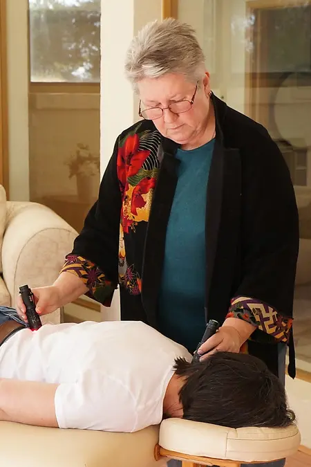 Kay demonstrating using Photopuncture Torches to activate the bladder meridian along the spine using a 2 torch technique.