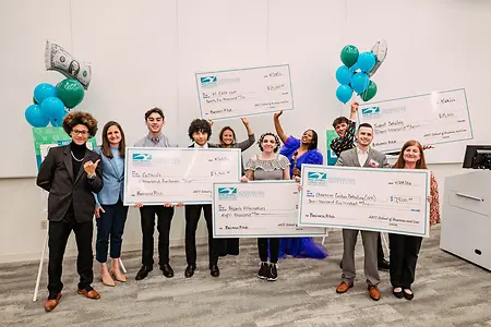 Awarding big checks to students who competed in AACC's Business Pitch Competition.