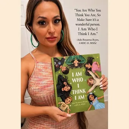 Here I am taking a picture of the children's book about positive affirmations that I wrote titled " I Am Who I Think I Am." I wrote one in English and Spanish. 