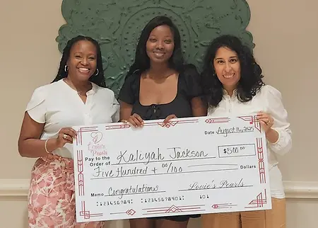 This photo captures the first teen mom from Lovie's Pearls to graduate from college. Statistically, less than 2% of teen moms graduate college by age 30....Kaliyah was 22! The check represents our gift to her for such an amazing accomplishment.