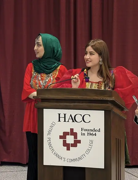 One of my favorite parts of working with refugee communities is creating opportunities for people to be seen for more than the challenges they have faced. During this refugee community event, alongside employment resources, job opportunities, and community partners, I helped bring a cultural fashion show to life giving refugees the chance to proudly represent their countries through traditional clothing and music. Watching different cultures share the same stage was a beautiful reminder that resettlement is not only about starting over; it is also about carrying your identity, culture, and traditions forward. And a little fun fact behind this photo: standing beside me is the best friend I met after coming to the United States. We found each other while both building new lives here, which makes this moment even more special to me. ❤️