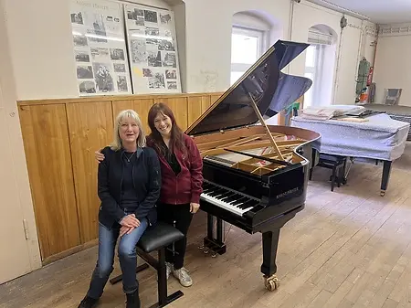Hannah with Annekatrin Förster, CEO and heir of August Förster Piano founded in 1859 in Germany, at the AF factory after Annekatrin told her that a convertible piano with two interchangeable keyboards that have different widths of keys for both large and small hands would be sent to NYC in September 2026. 