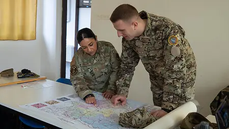 Reviewing road maps to develop a course for a convoy operations exercise.