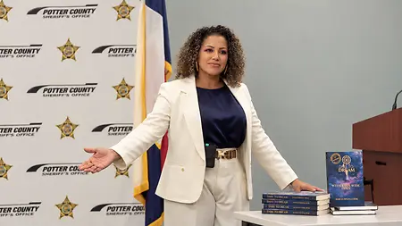 Author and inspirational speaker Marcia Regina Cook pictured at the Potter County Sheriff’s Office with her book, Dare to Dream with Eyes Wide Open. Through her writing and speaking, Marcia shares her personal journey of resilience and faith, encouraging others to find hope, embrace their worth, and pursue their dreams.